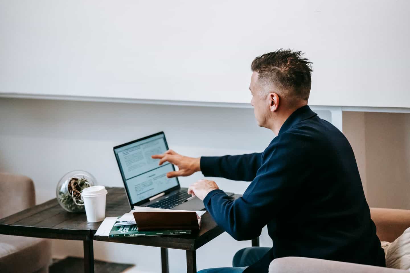 A person recording their screen on a laptop at a wooden desk