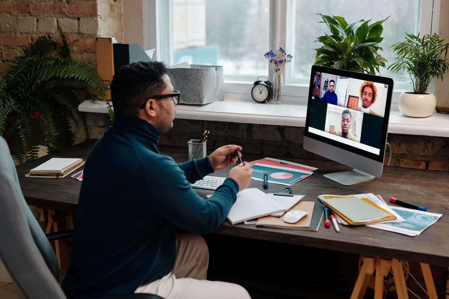 A person on a video call with their team from a home office